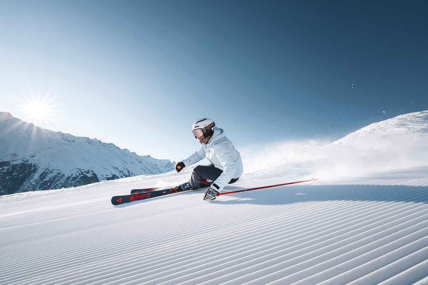 Skifahrer in voller Fahrt auf frisch präparierter Piste