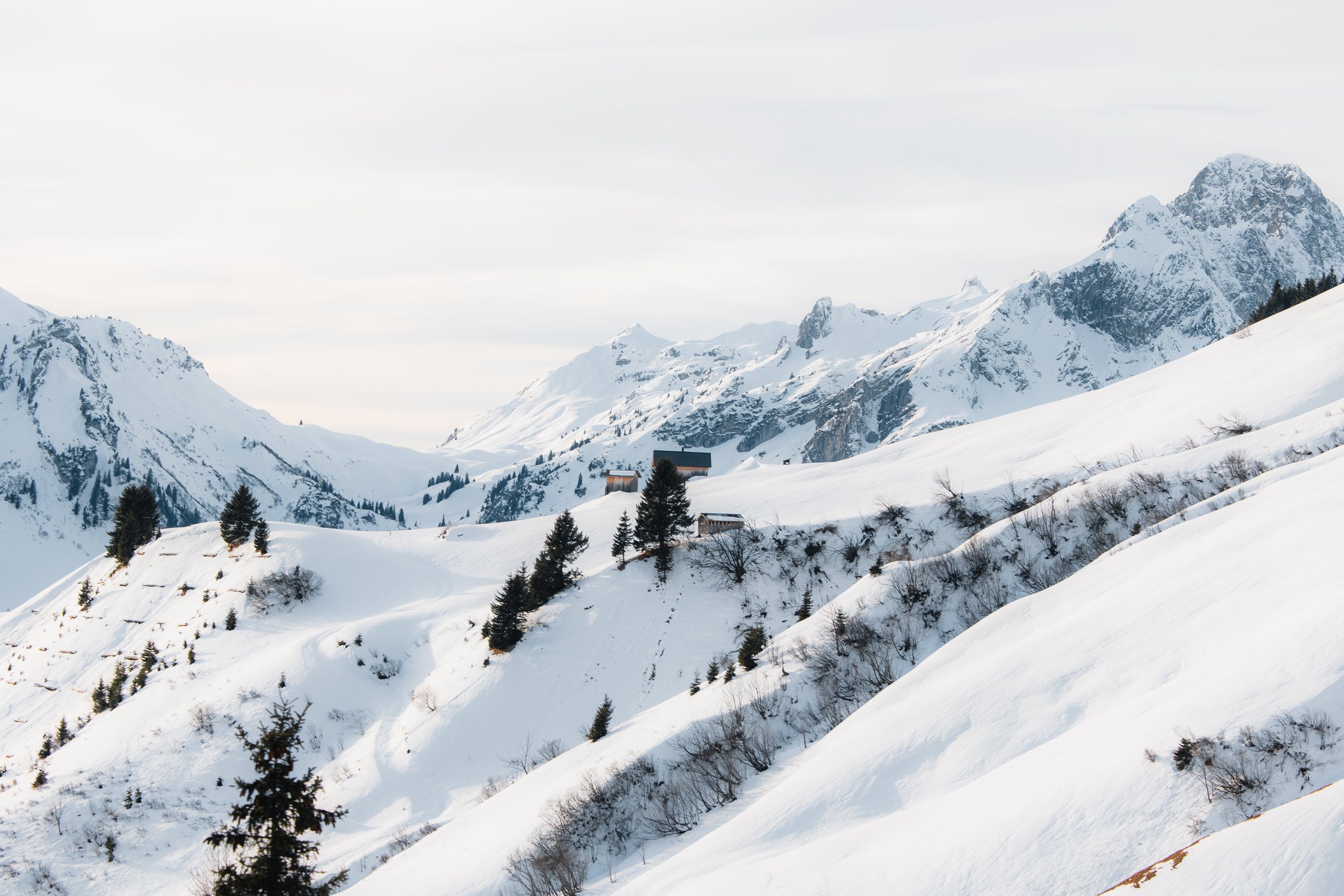Ruhiges Bergtal mit verschneiten Hütten bei Warth